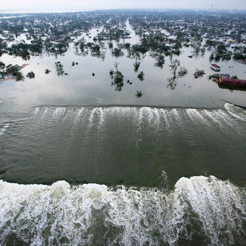 Water spills over a levee along the Inner Harbor Navigational Canal in the aftermath of Hurricane Katrina on Aug. 30, 2005 in New Orleans, La. (Photo by AFP/Getty)