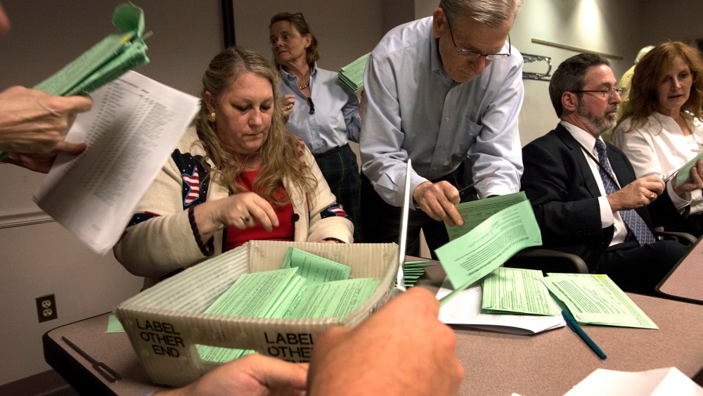 Fairfax County election board employees open provisional ballots from Fairfax County voters for the attorney general race in Fairfax, Va. on Nov. 12, 2013.
