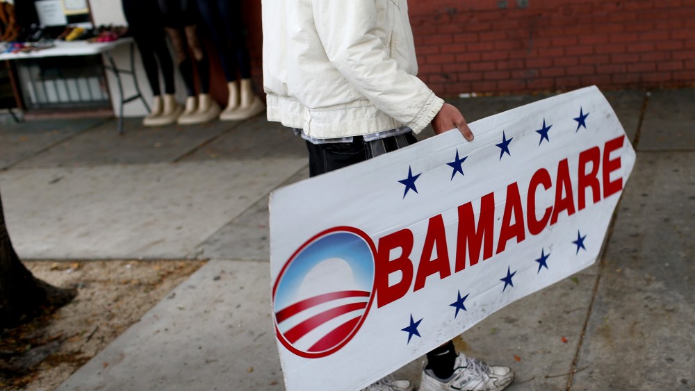 Pedro Rojas holds a sign directing people to an insurance company where they can sign up for the Affordable Care Act, also known as Obamacare, before the Feb. 15th deadline on Feb. 5, 2015 in Miami, Fl. (Photo by Joe Raedle/Getty)
