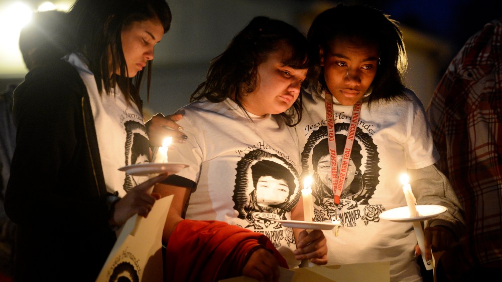 Zhakyra Cousin, center, Shia Brooks, left, and Markeesha McDade, right, during a Feb. 19, 2015 community vigil held in honor of Jessica Hernandez. (Photo by Andy Cross/The Denver Post via Getty)