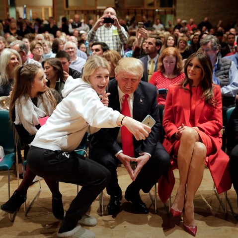 Republican presidential candidate Donald Trump, accompanied with wife, Melania, pauses for a selfie while visiting Saint Francis of Assisi Church, a caucus site, Feb. 1, 2016, in West Des Moines, Iowa. (Photo by Jae C. Hong/AP)
