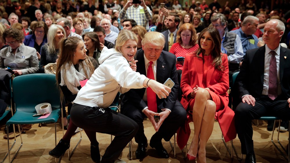 Republican presidential candidate Donald Trump, accompanied with wife, Melania, pauses for a selfie while visiting Saint Francis of Assisi Church, a caucus site, Feb. 1, 2016, in West Des Moines, Iowa. (Photo by Jae C. Hong/AP)