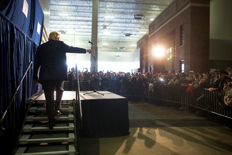 Republican presidential candidate Donald Trump, left, points to the crowd as he walks up the steps to speak in the overflow area at a rally, Jan. 9, 2016, in Ottumwa, Iowa. (Photo by Jae C. Hong/AP)