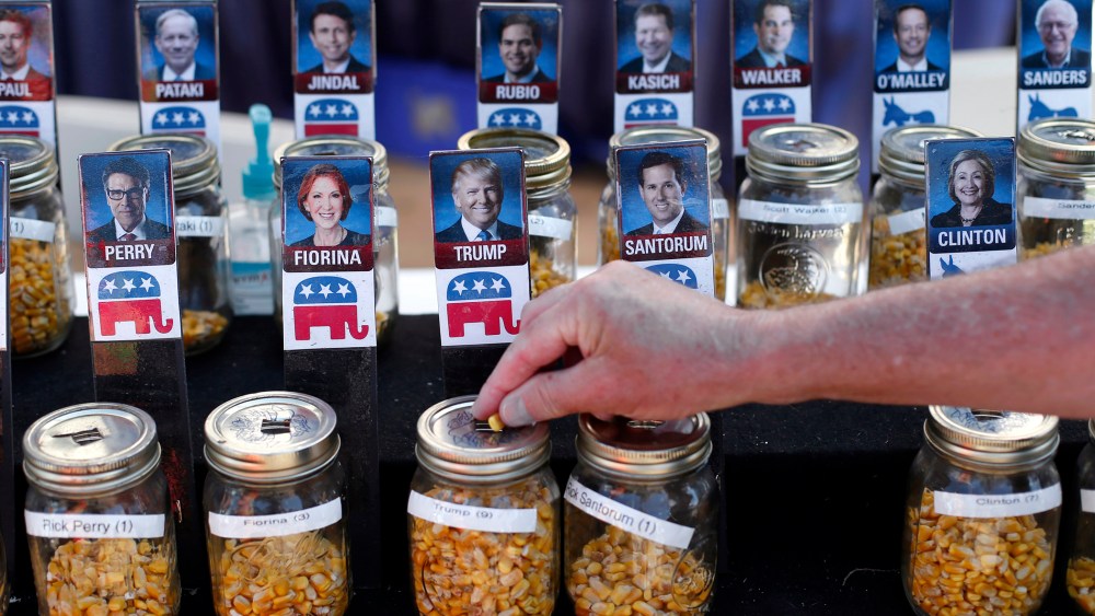 A visitor casts their vote with a kernel of corn for presidential candidate Donald Trump in a straw poll at the Iowa State Fair, Aug. 20, 2015, in Des Moines, Iowa. (Photo by Paul Sancya/AP)