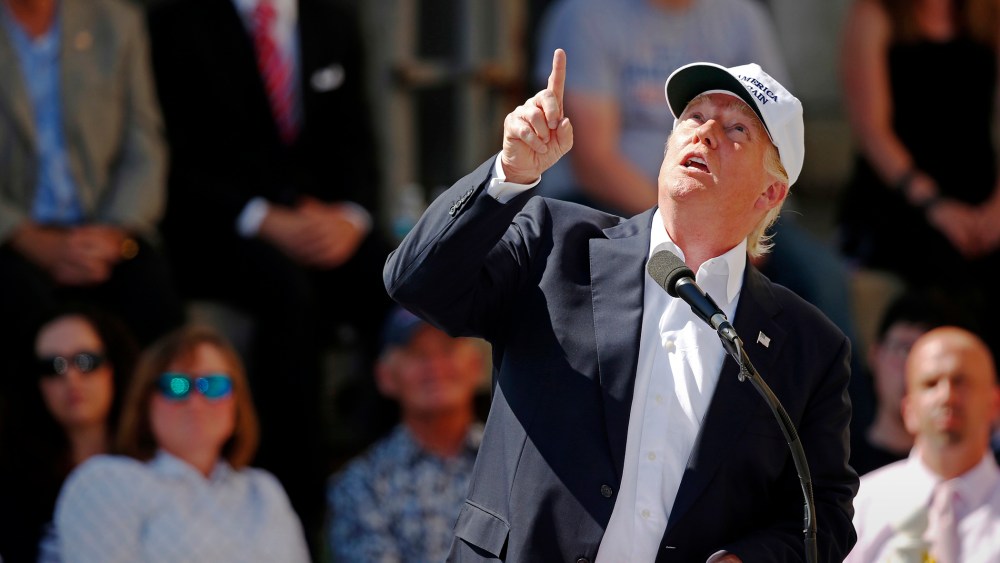 Republican presidential candidate Donald Trump points to an airplane passing overhead at a town hall-style campaign event at the former Osram Sylvania light bulb factory, June 30, 2016, in Manchester, N.H. (Photo by Robert F. Bukaty/AP)
