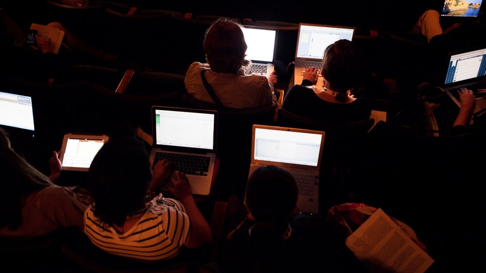 People work on their laptops while attending a lecture. (Photo by Martin Adolfsson/Gallery Stock)