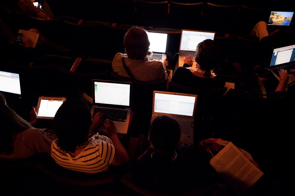 People work on their laptops while attending a lecture. (Photo by Martin Adolfsson/Gallery Stock)