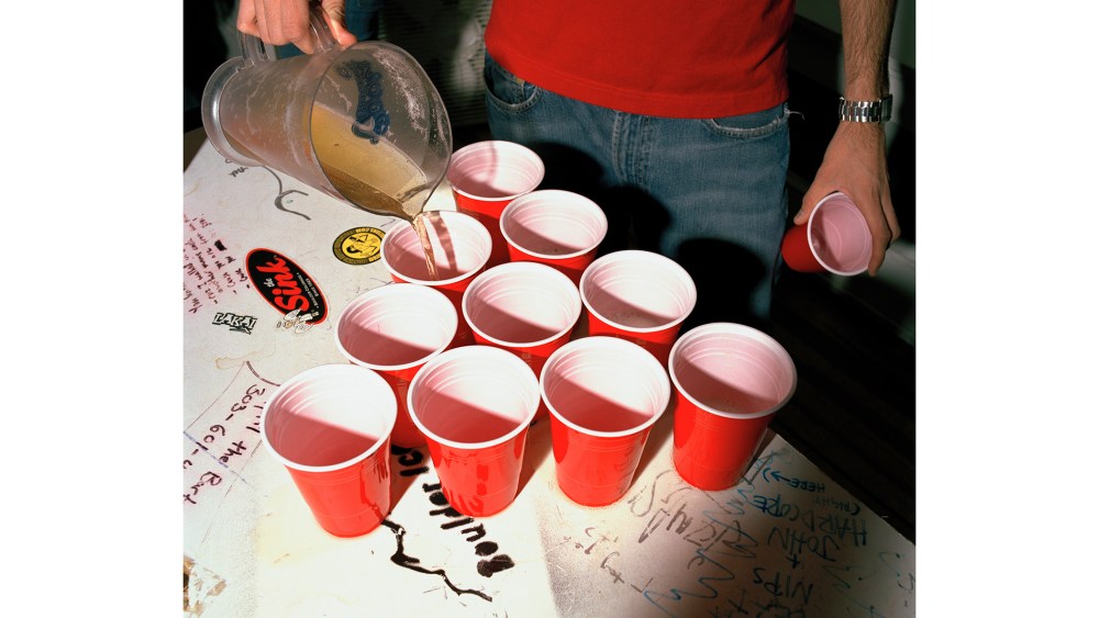 A college student fills cups of beer. (Photo by Brian Finke/Gallery Stock)