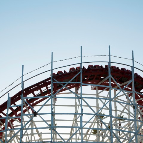 Roller coaster cars turn on a curve. (Photo by Stephen Tamiesie/Gallery Stock)