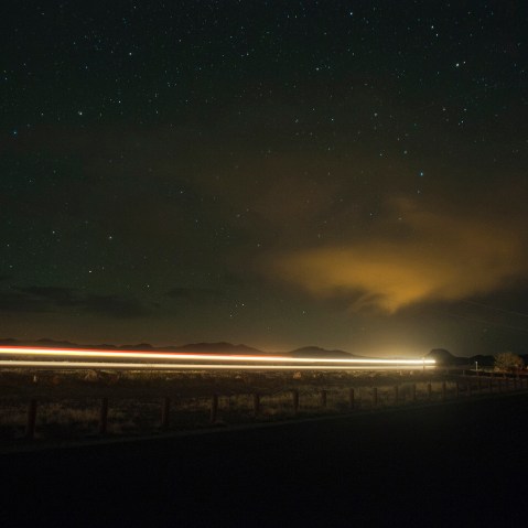 A car drives down the highway at night under a sky full of stars. (Photo by Justin Carrasquillo/Gallery Stock)