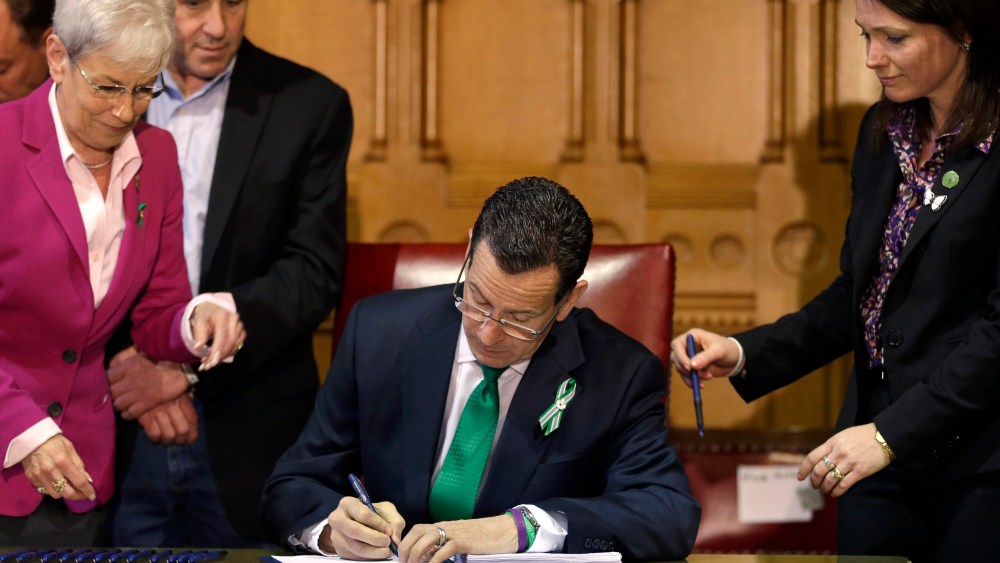 Connecticut Gov. Dannel Malloy signs new legislation at the Capitol in Hartford, Conn. on April 4, 2013, that includes new restrictions on weapons and large capacity ammunition magazines, a response to last year's deadly school shooting in Newtown. ...