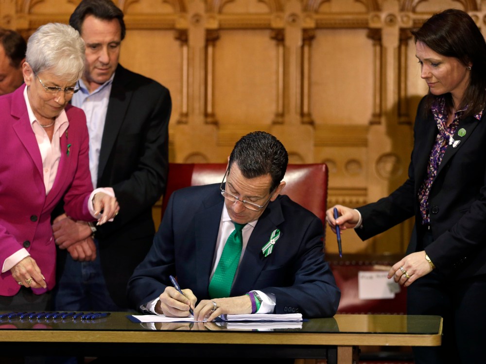 Connecticut Gov. Dannel Malloy signs new legislation at the Capitol in Hartford, Conn. on April 4, 2013, that includes new restrictions on weapons and large capacity ammunition magazines, a response to last year's deadly school shooting in Newtown. ...