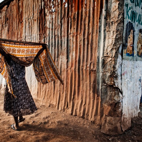 A woman covers her head with a shawl.