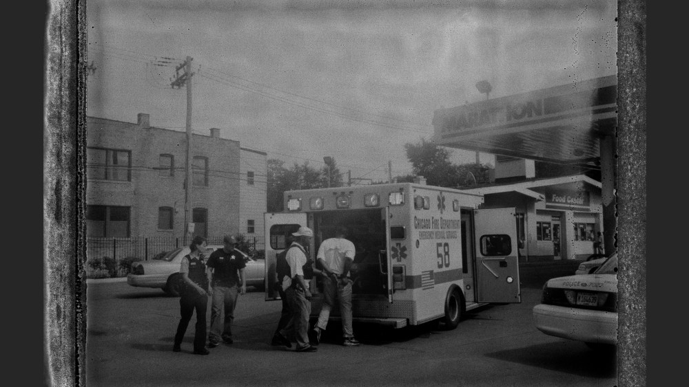 A suspect who was caught with a gun is led in handcuffs into an ambulance for treatment after being tased by Chicago Police.