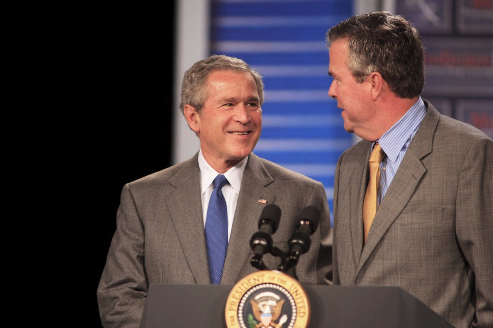 President George W. Bush (L) smiles at his brother Florida Governor Jeb Bush before making remarks at an event in Sun City Center, Fla., on March 8, 2006. (Photo by Chris Livingston/EPA)