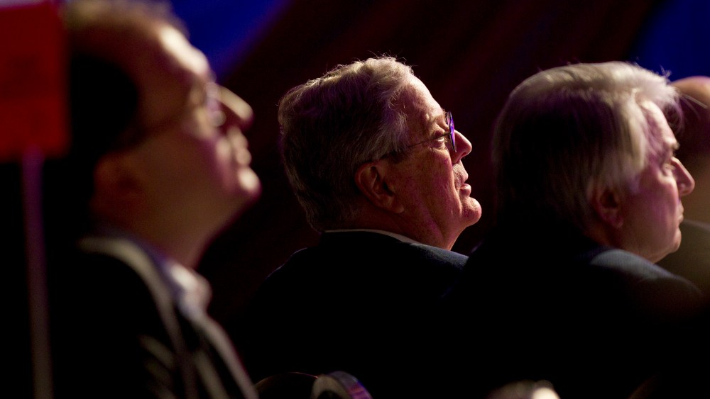 David Koch listens to Mitt Romney speak in Washington on Nov. 4, 2011.