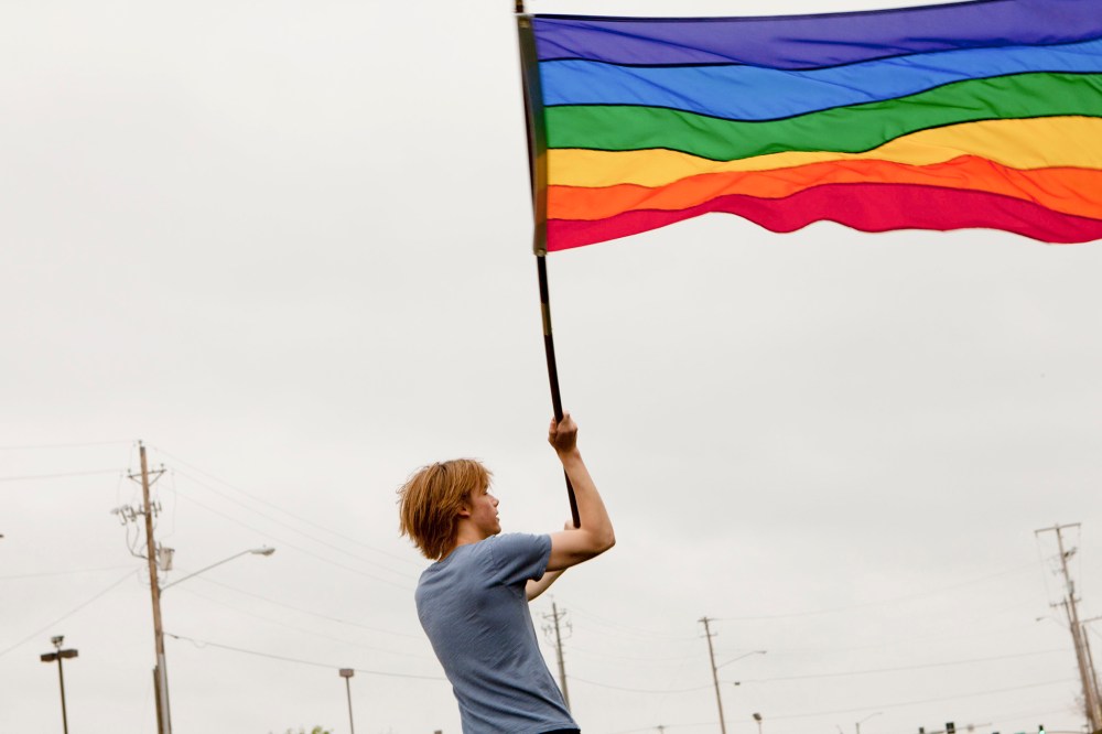 Gay rights protester Bob Gilchrist waves a flag outside the Hilton hotel in Jackson, Miss., March 8, 2012.