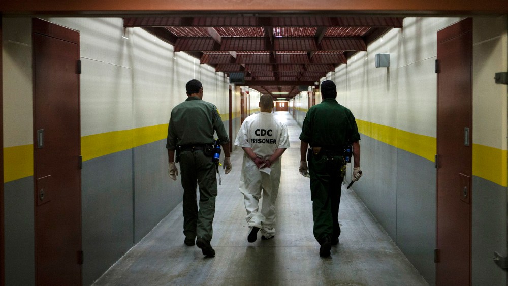Two correction officers escort a prisoner down a corridor at Pelican Bay Prison in Crescent City, Calif. on June 8, 2012.