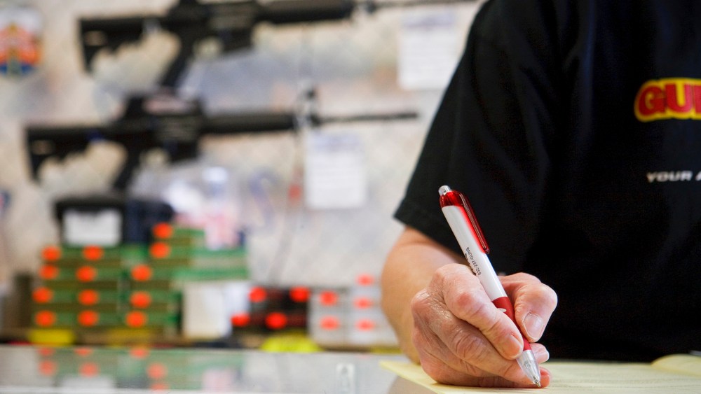 An employee reviews a customer's application as part of a background check for a handgun sale, in Houston, Texas.