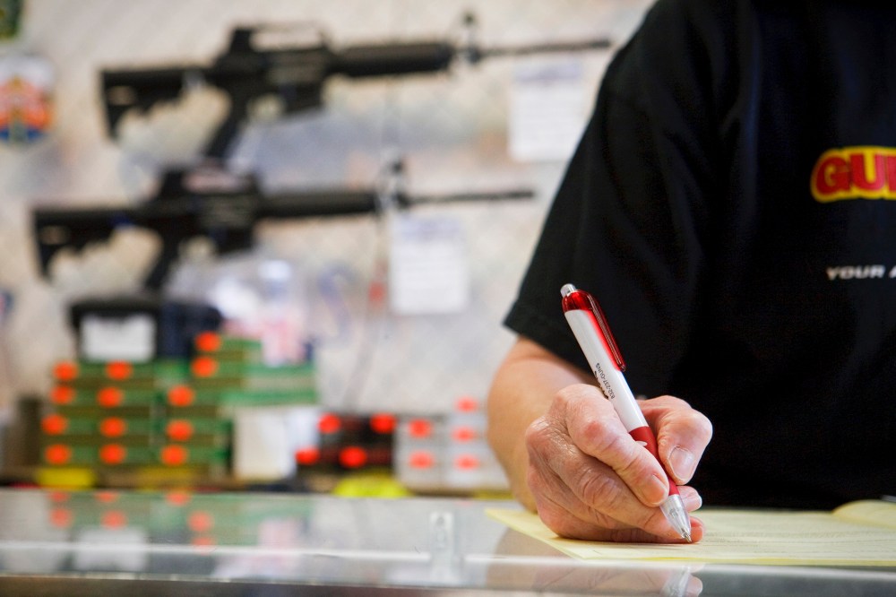An employee reviews a customer's application as part of a background check for a handgun sale, in Houston, Texas.