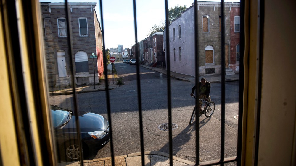 A resident rides his bike in an abandoned block in East Baltimore, Oct. 28, 2013.