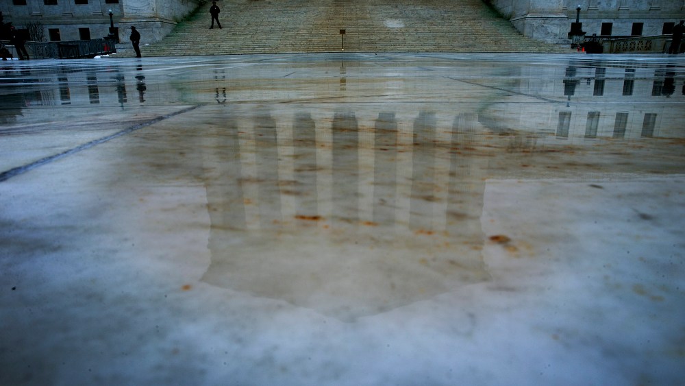 Rain water reflects the U.S. Supreme Court building in Washington, Dec. 9, 2013.
