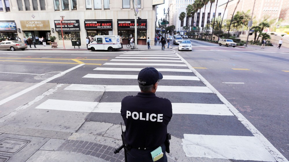 An LAPD officer watches a downtown intersection in Los Angeles, Calif., Dec. 17, 2013.