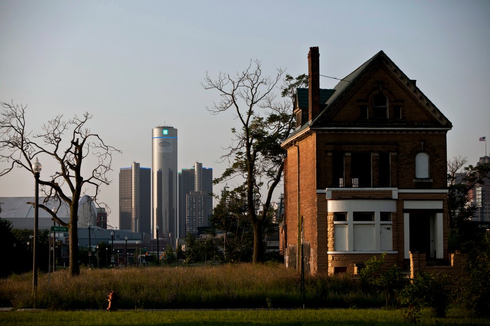 Early morning light falls on an a vacant, boarded up house as downtown Detroit is seen in the background, a day after the city filed for bankruptcy protection in court, in Detroit, on July 19, 2013.