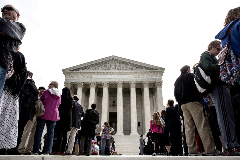 Members of the public wait in line to hear oral arguments at the Supreme Court in Washington.
