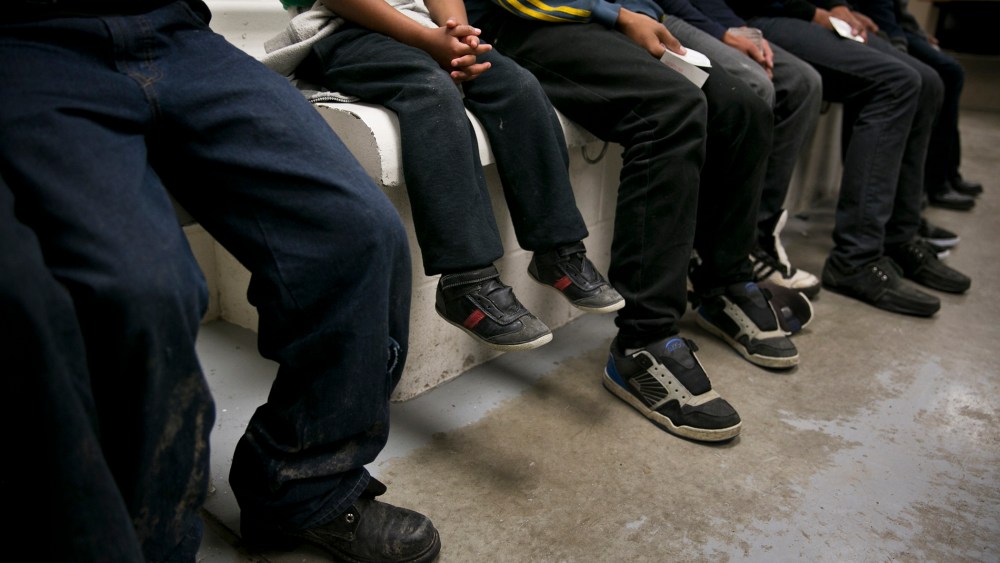 A child from Honduras sits with older youths being processed at a U.S. Border Patrol station in Brownsville, Texas, March 25, 2014. (Photo by Todd Heisler/The New York Times/Redux)