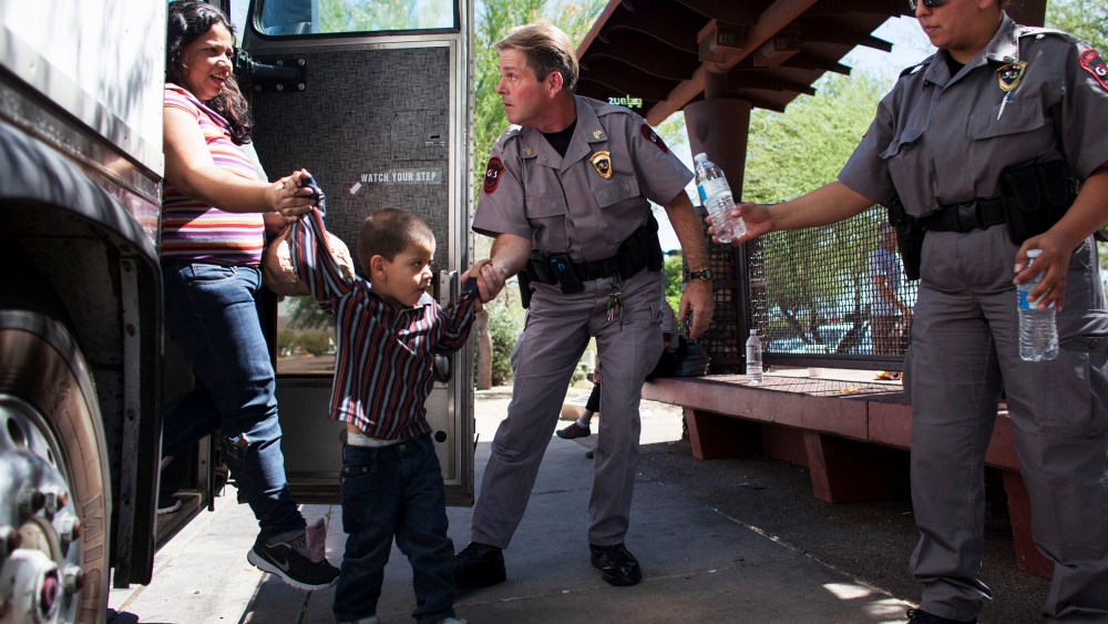 Immigrants who were bussed from Texas are released due to lack of manpower next to a Greyhound station in Phoenix, June 4, 2014.