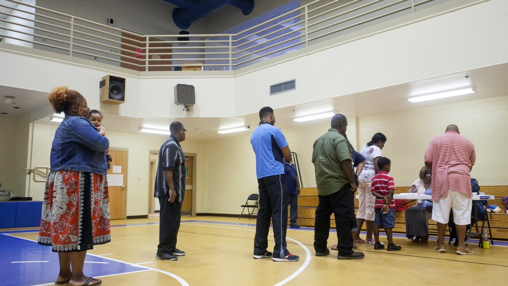 Voters wait in line to cast their ballot in a Republican primary runoff at the New Hope Baptist Church in Jackson, Miss., June 24, 2014.