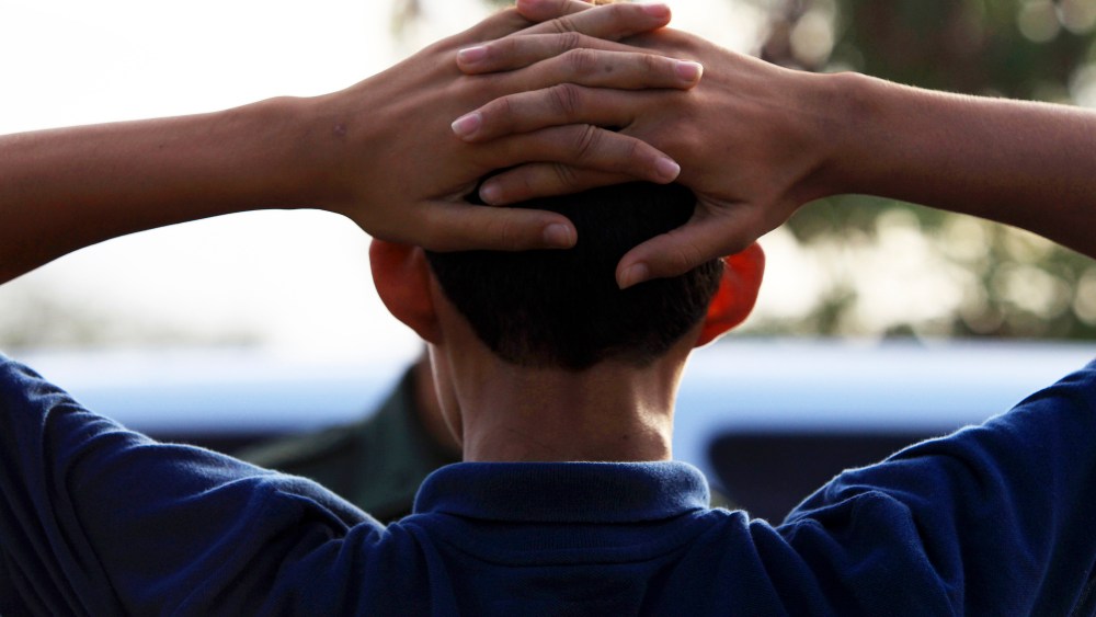 A young boy waits as Border Patrol agents process a group of 22 migrants who just crossed the Rio Grande near McAllen, Texas, June 18, 2014.
