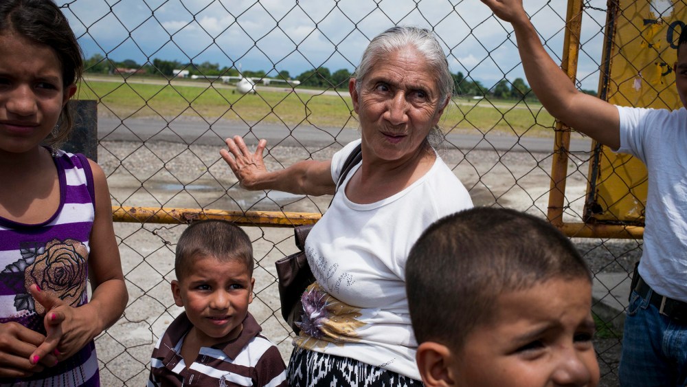 A family waits for a plane of migrants deported from the United States, arriving at Ramon Villeda Morales Airport in San Pedro Sula, Honduras, July 14, 2014.