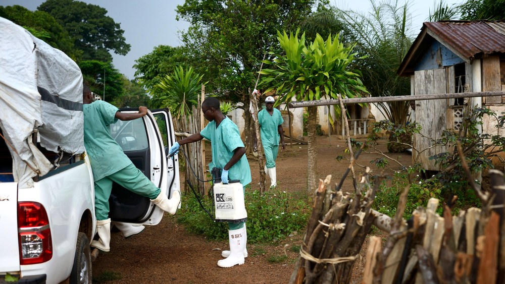Doctors Without Borders workers wearing protective clothing disinfect materials at a clinic in Teldou, Guinea, July 10, 2014.