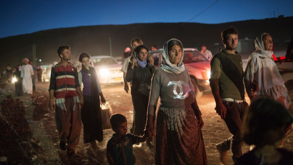 Refugees from the Yazidi religious minority cross the Syrian border into Faysh Khabur, in Iraq's northern Dohuk province on Aug. 9, 2014. (Adam Ferguson/The New York Times/Redux)