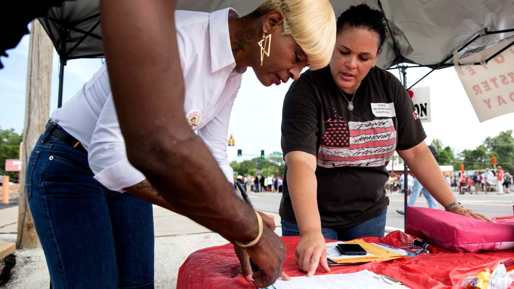 Shiron Hagens, right, helps resident Rita Foley register to vote at a rally in Ferguson, Mo., Aug. 30, 2014.