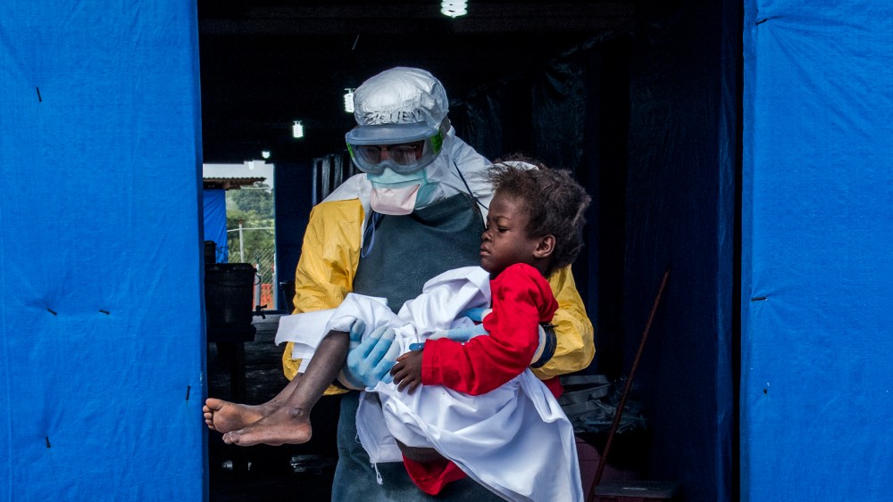 Dr. Steven Hatch carries Blessing Gea, 9, from the suspected ward to the confirmed high-risk ward after a blood test showed her positive for Ebola, at a clinic run by the International Medical Corps in the Suakoko of Liberia, Oct. 10, 2014.