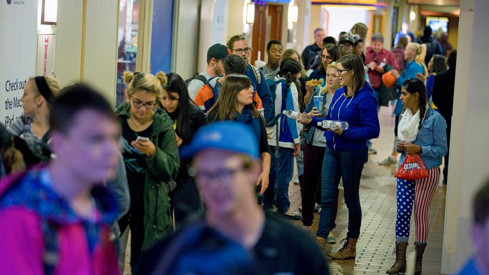 People wait in line to vote at busy polling facility on the Auraria Campus in Denver, Colo.