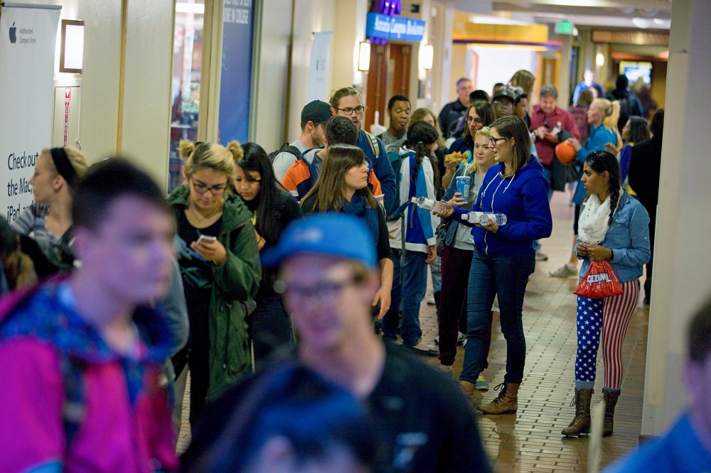 People wait in line to vote at busy polling facility on the Auraria Campus in Denver, Colo.