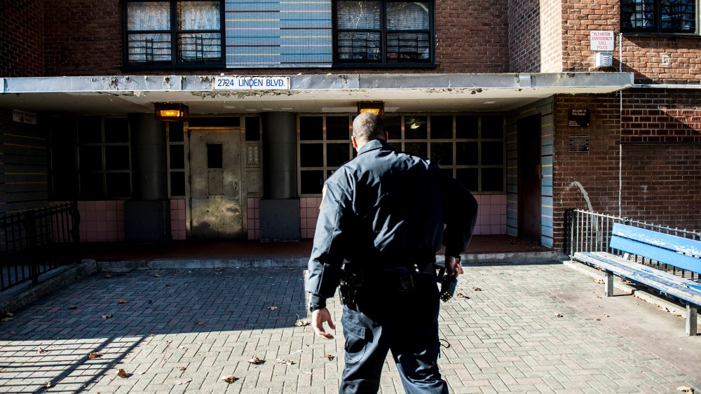 An officer outside the Louis H. Pink Houses, where a man was shot dead by police the night before, in the Brooklyn borough of New York, Nov. 21, 2014. (Photo by Robert Stolarik/The New York Times/Redux)
