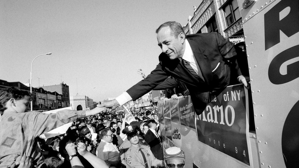 From a campaign bus, Gov. Mario Cuomo of New York shakes hands with supporters on Oct. 30, 1994.