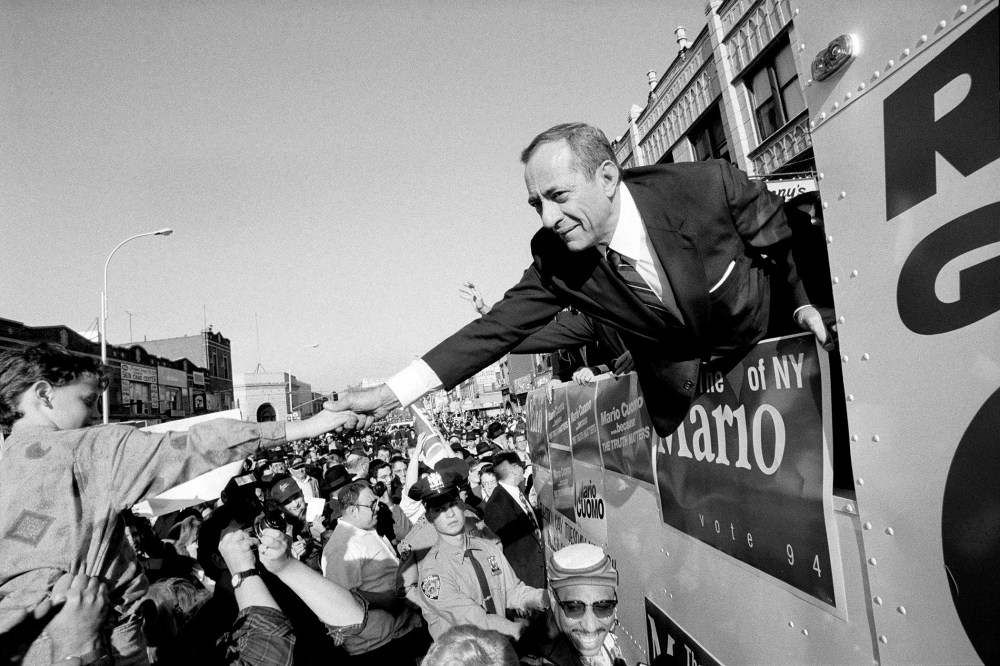 From a campaign bus, Gov. Mario Cuomo of New York shakes hands with supporters on Oct. 30, 1994.