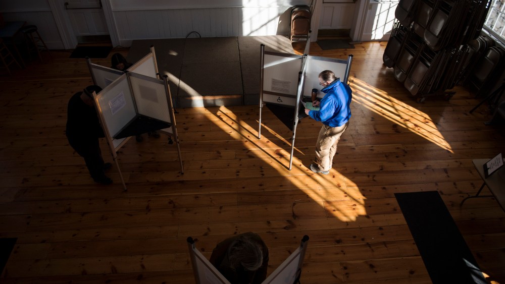Voters cast their ballots in a polling station at the Ripton Town Clerk's office in Ripton, Vt.