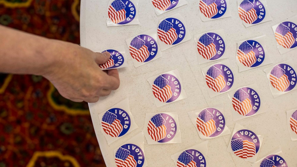 A voter picks up a sticker after casting their ballot in a polling station at the Mahatma Ghandi Center in Ballwin, Mo. (Photo by Whitney Curtis/The New York Times/Redux)