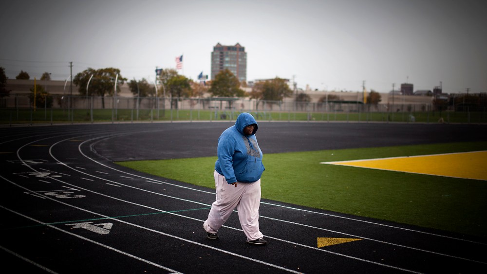A young man exercising on a running track surrounding a football field in Detroit, Michigan, October 14, 2012.