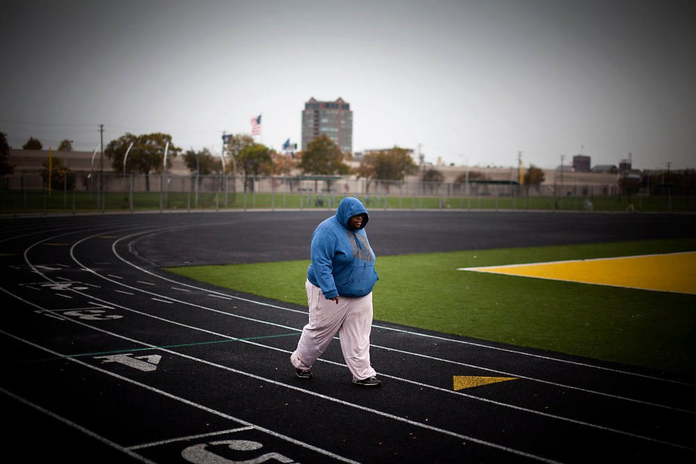 A young man exercising on a running track surrounding a football field in Detroit, Michigan, October 14, 2012.