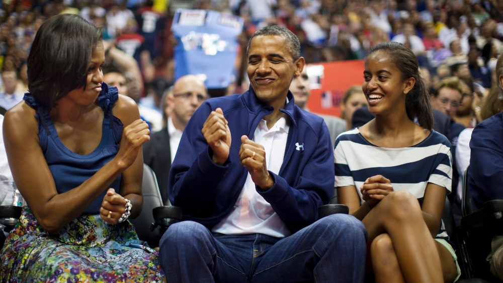 US President Barack Obama does a little dance while First Lady Michelle Obama and Malia Obama look on in Washington DC on July 16, 2012. (Photo by Jim Lo Scalzo/EPA)