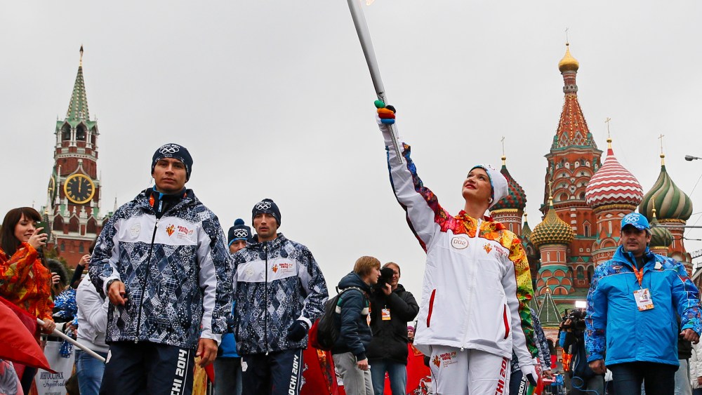 Russia's artistic gymnastics Olympic champion Svetlana Khorkina carries the Olympic flame during the start of the torch relay race in Moscow, October 7, 2012.