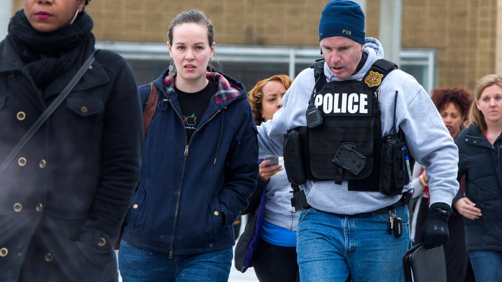 Police escort shoppers and employees out of the Columbia Mall after a shooting left three people dead, Jan. 25, 2014, in Columbia, Md.